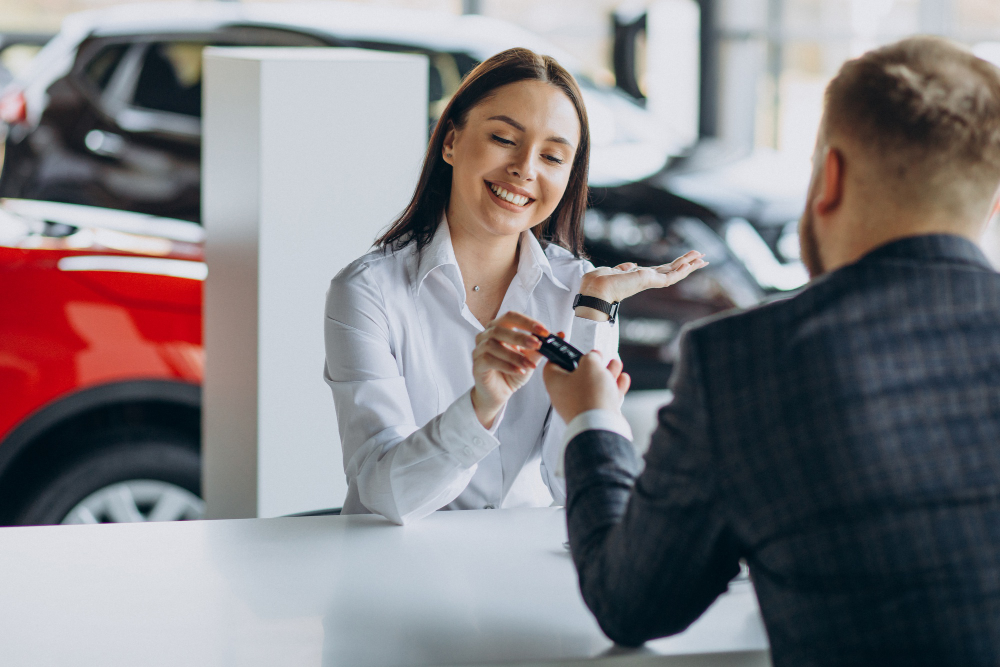 Une femme récupère des clés de voiture chez un concessionaire